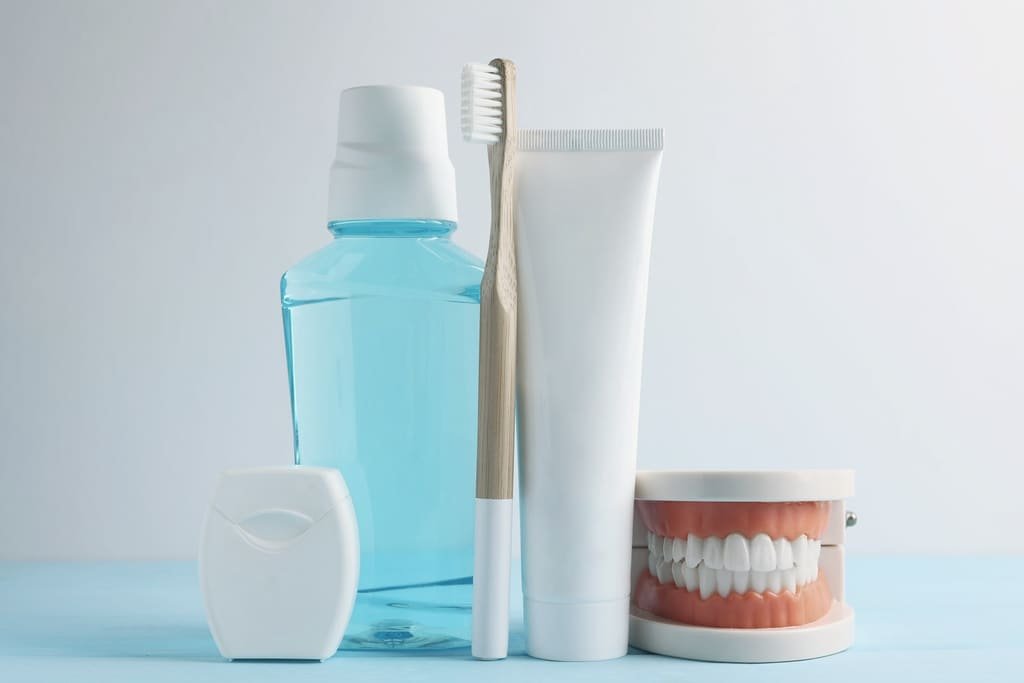 Mouthwash, toothpaste, a toothbrush, dental floss and a dental model