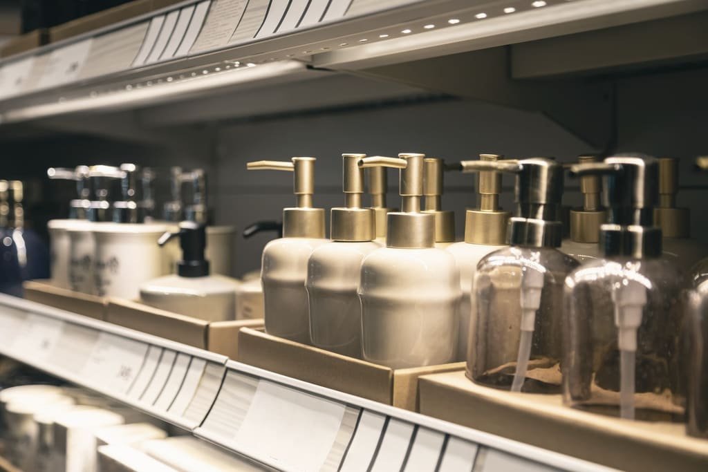 Shampoo and liquid soap dispensers lined up on a retail shelf
